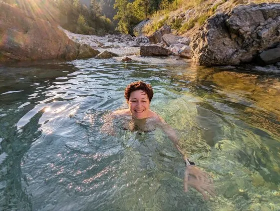 Carla immersa nell'acqua di un torrente di montagna